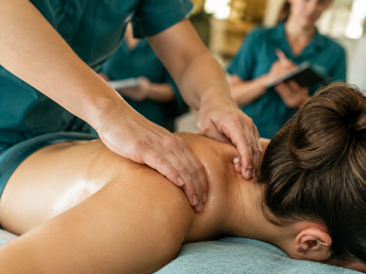 Praxistraining: Massagetechniken werden unter Anleitung an der Schulungsliege geübt